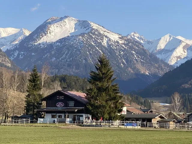 Landhof und Berge im Hintergrund