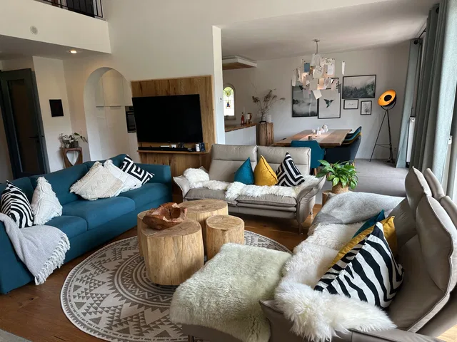 Wohnbereich der Waldlounge mit Sofas, Holztischen und offener Küche.