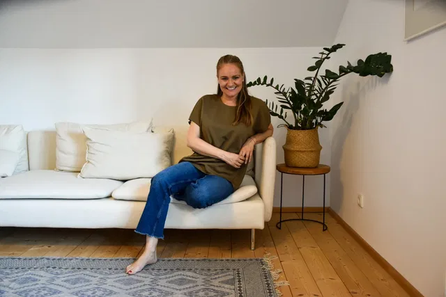 Uta Waldhausen sitzt auf einem weißen Sofa im hellen Coachingraum.
