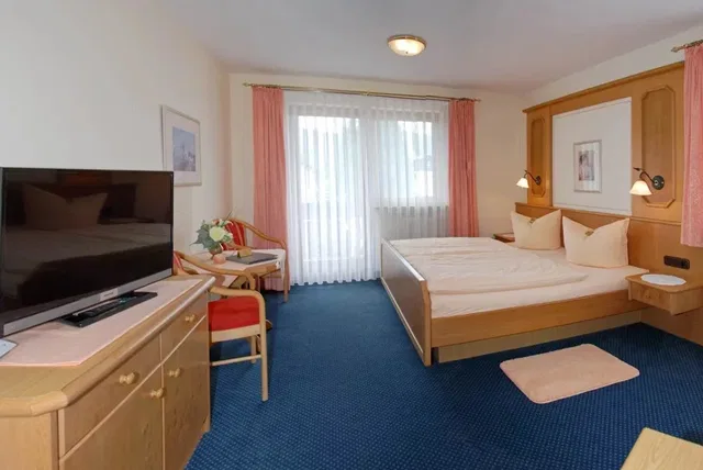 Doppelzimmer Deluxe mit Doppelbett, Sitzbereich und Balkonzugang