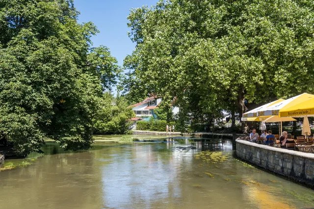 Aachtopf mit Uferweg und Restaurantterrasse an der Aachquelle