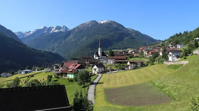 Blick von Norden auf Wenns mit Kirche und grünen Hängen.