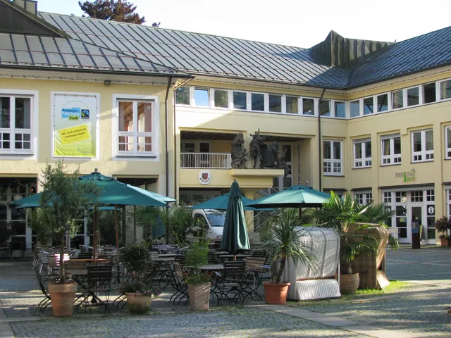 Rathaus-Innenhof mit Café-Tischen, Stühlen und Sonnenschirmen