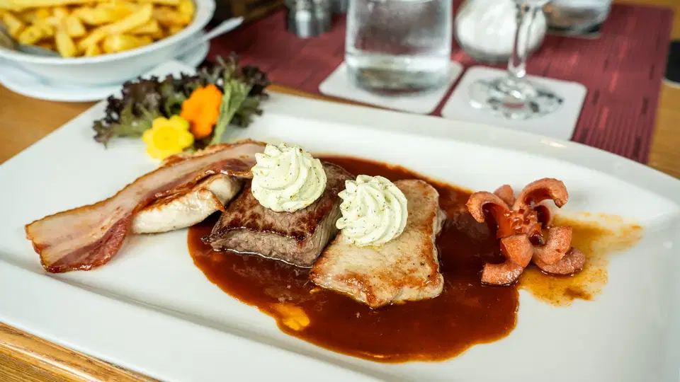 Fleischgericht mit Bratensauce und Kräuterbutter im Gasthof Alpenblick