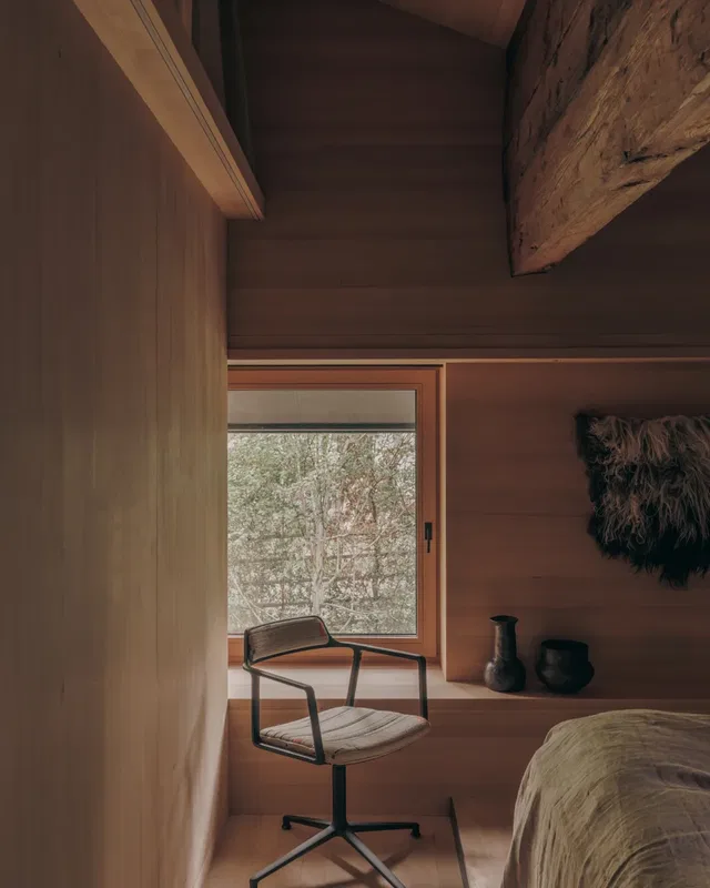 Holzraum mit Fensterbank, Stuhl am Fenster und rustikaler Deko