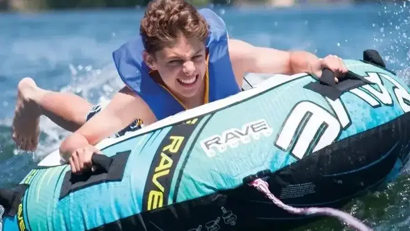 Gast mit Schwimmweste auf einem aufblasbaren Wassersportgerät