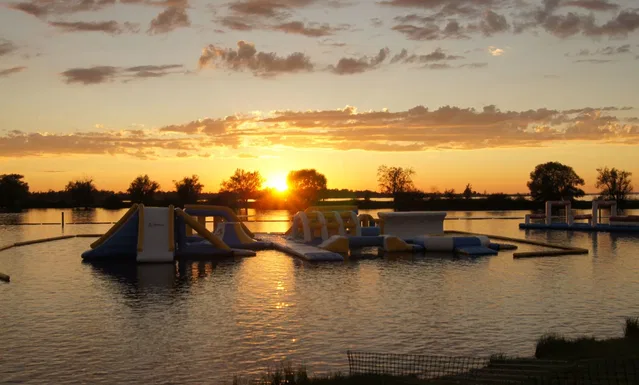 Wasserpark-Inflatable auf einem See bei Sonnenuntergang.
