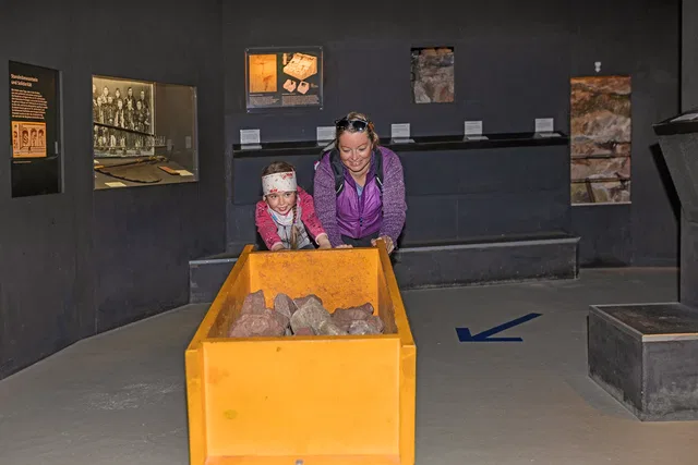 Erwachsene und Kind mit einem Grubenhunt in der Bergbau-Ausstellung