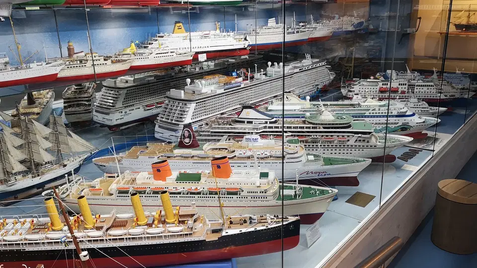 Modellschiffsammlung in Glasvitrine mit vielen Kreuzfahrtschiffen
