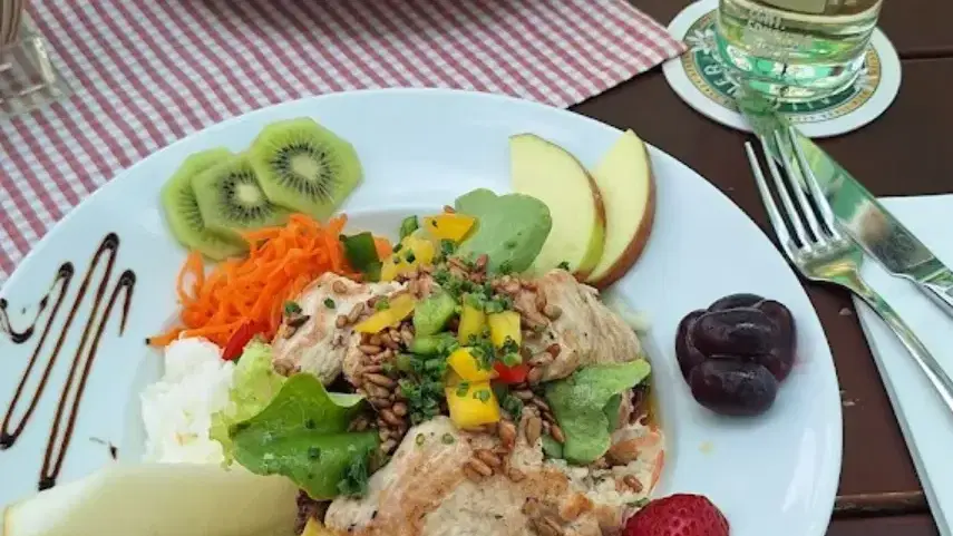 Zwei Gerichte am Tisch mit Salat und Obstgarnitur