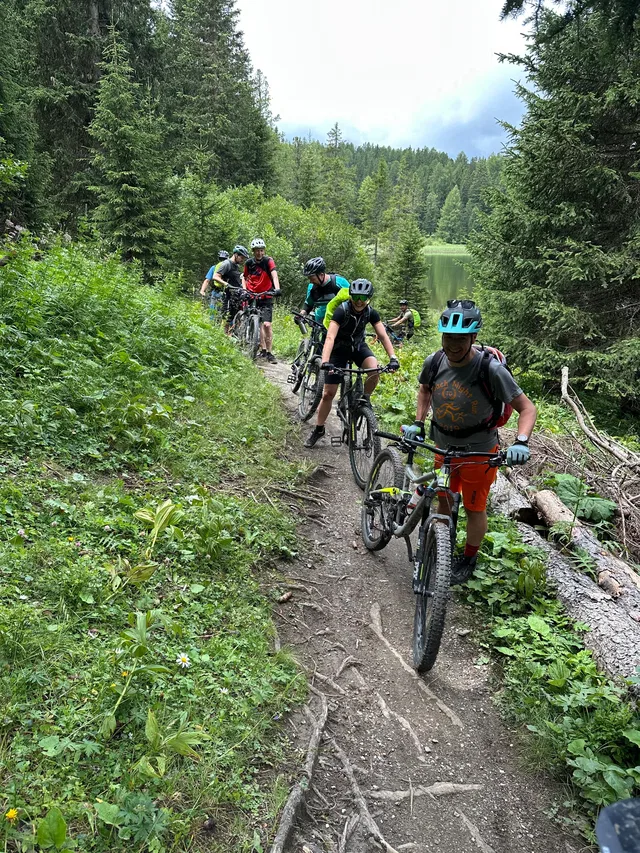 Mountainbiker auf einem Waldweg neben einem kleinen See