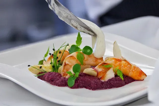 Garnelen auf Bete-Püree mit Kräutern, Sauce fließt darüber
