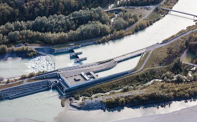 Luftaufnahme eines Staudamms mit Flussarm und Brücke
