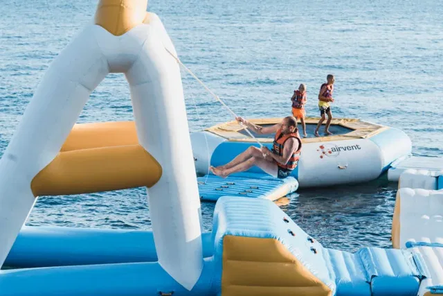 Personen auf einem aufblasbaren Wasserpark im Meer
