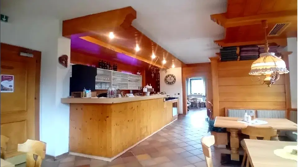 Theke im rustikalen Restaurant mit Holzwänden und Holztischen
