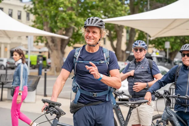 Radfahrende mit Helmen bei einem gemeinsamen Halt auf einem Platz