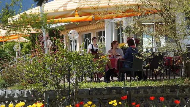 Gartenterrasse des Hotels Rosenstock mit orangefarbenen Markisen