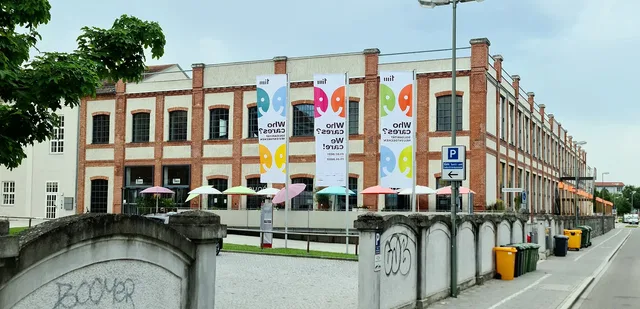 Historisches Backsteingebäude des miR-Museums mit bunten Bannern und Sonnenschirmen