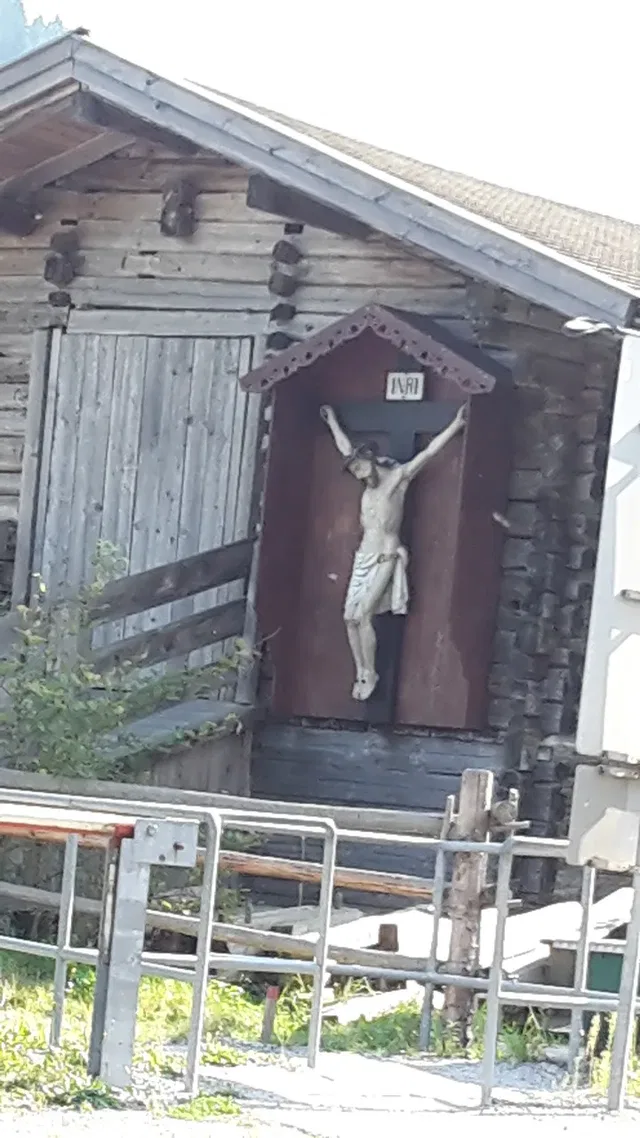 Kruzifix an einer alten Holzhütte