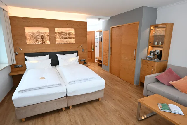 Hotelzimmer mit zwei Betten und Bergfotografien