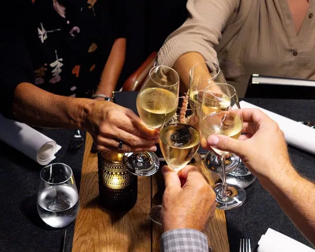 Gäste stoßen in der Ondersch Genusswirtschaft mit Wein an