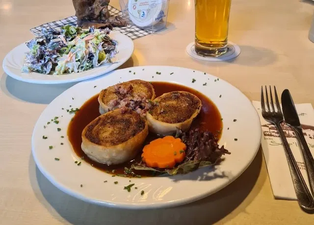 Drei gebratene gefüllte Rollen mit Sauce und Salat