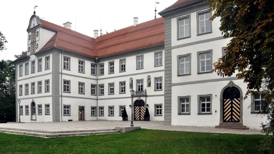 Schloss Kisslegg mit rotem Dach, hellgrauer Fassade und vielen Fenstern.