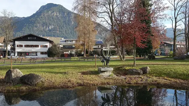 Kurpark in Oberstdorf mit Teich, Bäumen und Schattenberg im Hintergrund. Ortsmotiv.