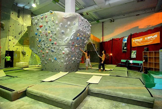 Boulderwand mit Griffen und Bodenmatten als Symbolbild für Hallenbouldern