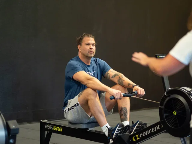 Sportler beim Rudern auf einem Ergometer