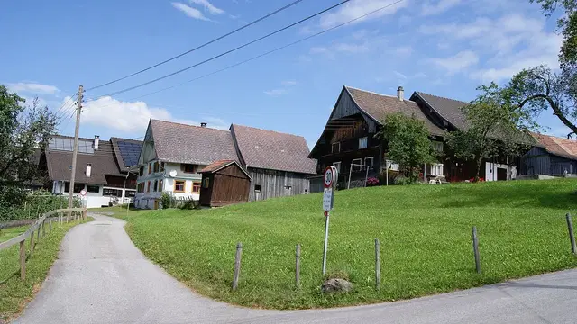 Häuser und grüne Wiesen in der Dornbirner Bergparzelle Stüben. Ortsmotiv zur Ausflugsplanung.