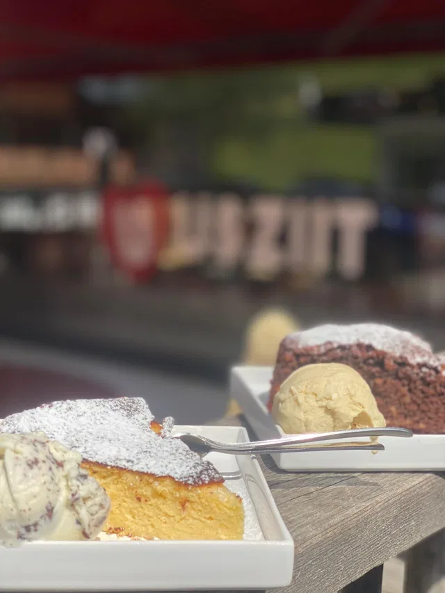 Dessert-Teller mit Kuchen und Eis im Freien, Puderzucker