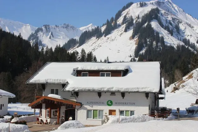 Alpenhotel Widderstein im Winter vor verschneiten Bergen