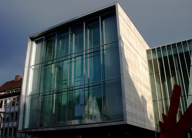 Modernes Gebäude mit Glasfassade und roter Skulptur