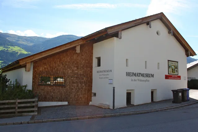 Heimatmuseum in der Widumspifte vor einer Berglandschaft