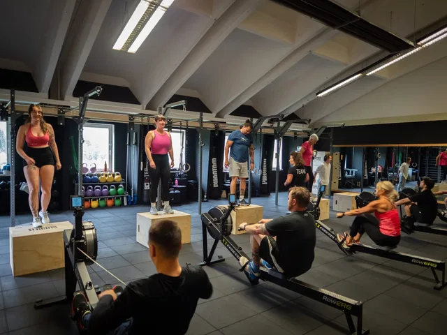 CrossFit-Gruppentraining mit Rudergeräten und Sprungboxen