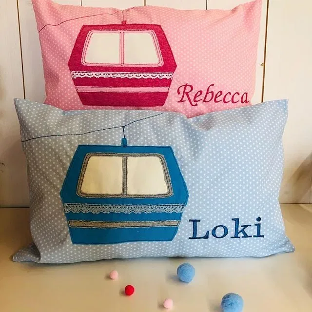 Zwei personalisierte Kissen mit Gondelmotiven in Rosa und Blau.