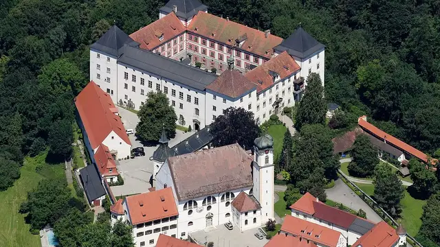 Luftaufnahme von Schloss Wolfegg mit Kirche und bewaldetem Schlossberg. Ortsmotiv zur Ausflugsplanung.