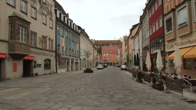 Historische Häuserfassaden und gepflasterte Kaiser-Max-Straße in Kaufbeurens Altstadt. Ortsmotiv zur Ausflugsplanung.