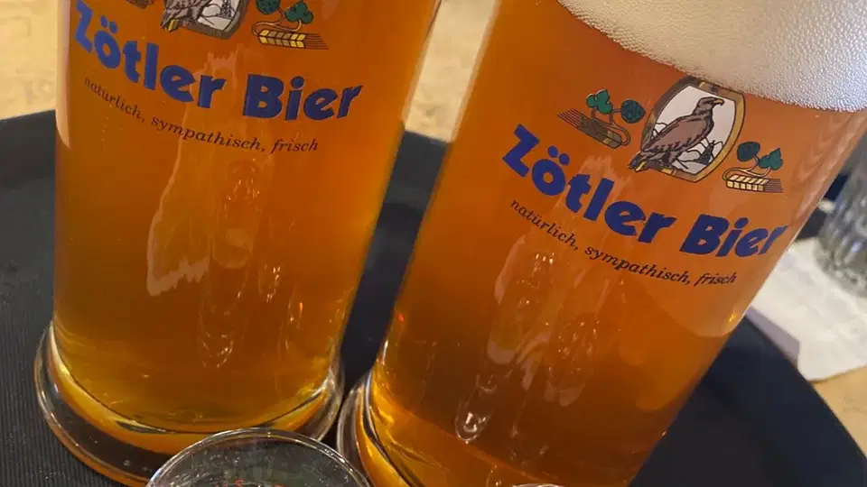 Zwei Zötler Bier Gläser mit Schaumkrone auf Tisch.