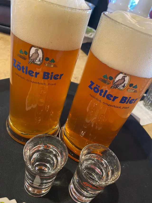 Zwei Zötler Bier Gläser mit Schaumkrone auf Tisch.