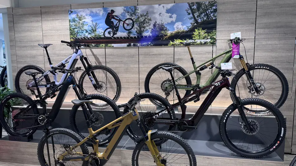 Mehrere ausgestellte Mountainbikes vor einem Wandfoto mit einem fahrenden Mountainbiker