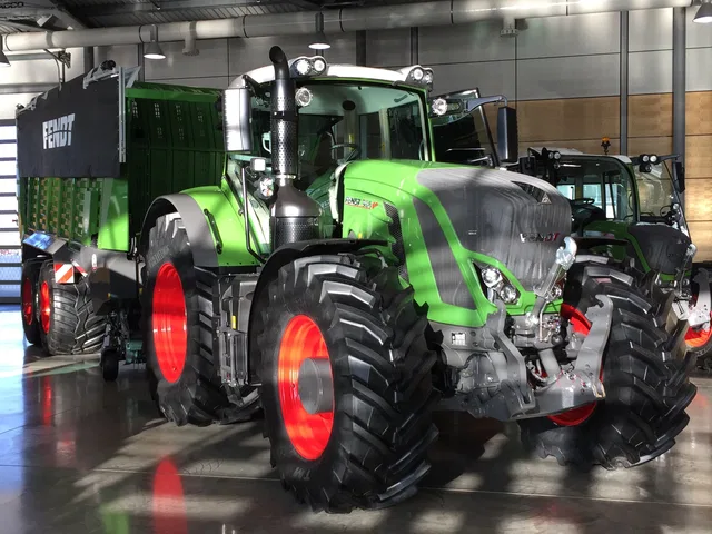 Großer grüner Fendt-Traktor mit roten Felgen in einer Ausstellungshalle.