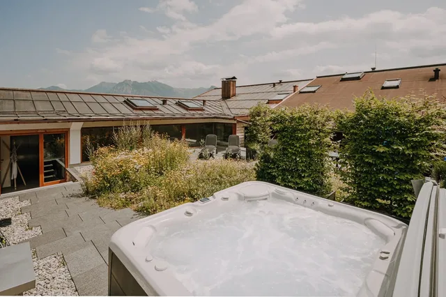Whirlpool auf der Dachterrasse mit Blick auf Dächer und Berge.