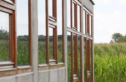 Fassade mit hohen Fenstern neben einem Maisfeld