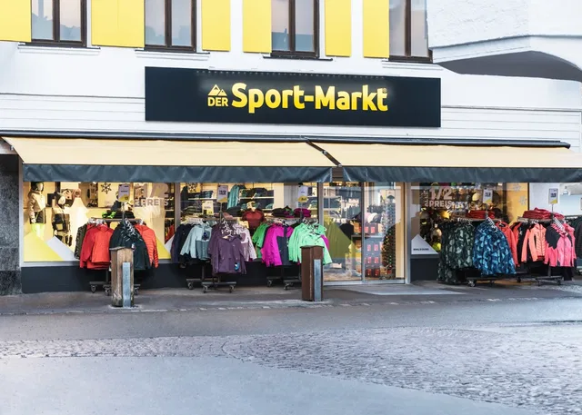 Außenansicht des Sport-Markts in Oberstdorf mit bunten Outdoor-Jacken im Schaufenster.