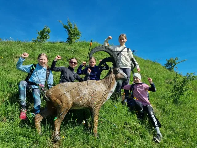 Gruppe neben einem Steinbock-Tierziel auf einer Wiese