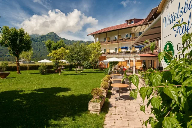 Gartenterrasse am Wittelsbacher Hof mit Tischen und Blick auf die Berge