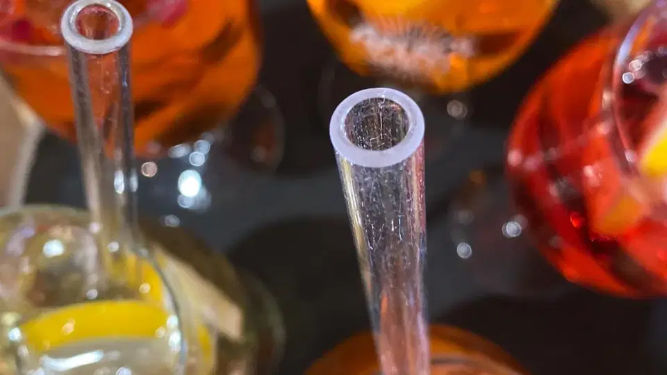 Mehrere Cocktails in Gläsern mit Strohhalmen, Eis und Orangenscheiben