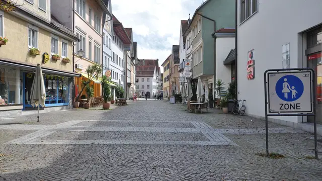 Gepflasterte Marktstraße in Leutkirch mit farbigen historischen Häuserfassaden auf beiden Seiten. Ortsmotiv zur Ausflugsplanung.